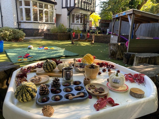 Large outdoor green space with tables set up for sensory play at Partou Leo
