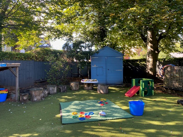 Grass area with shed and rug with plastic hoops at Partou Leo