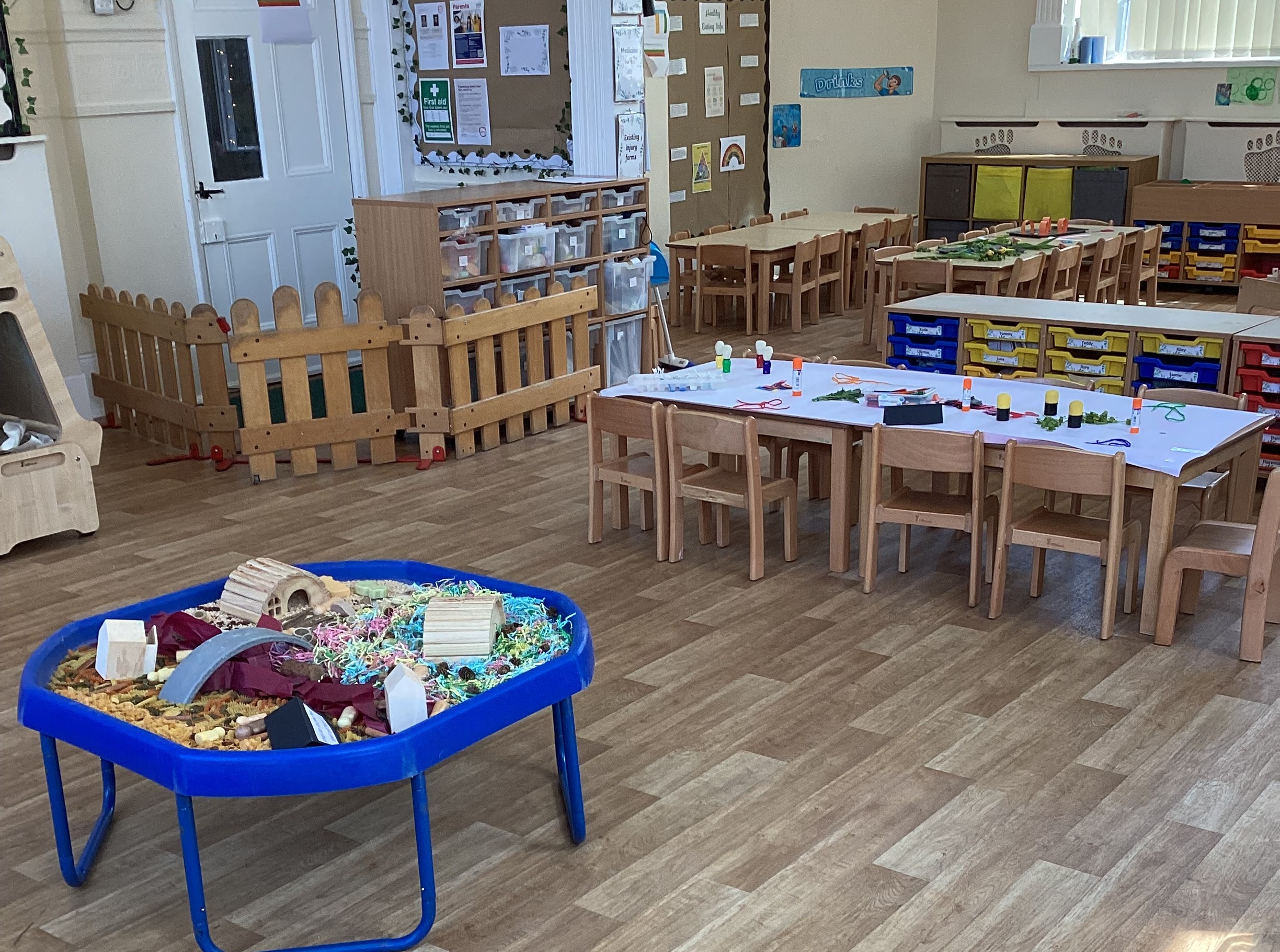 Sensory tray with shredded paper next to tables and chairs and activities at Partou Footprints nursery