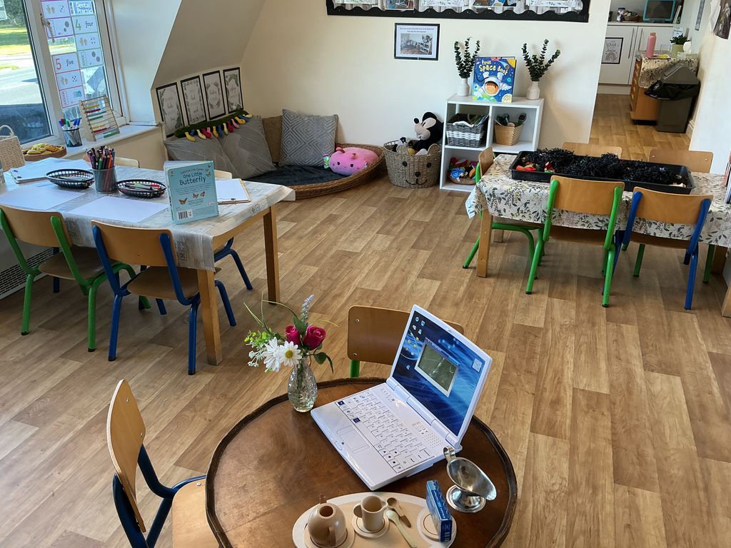 Toy laptop and table and chairs in home role play corner at Partou Acorns in Adel nursery and pre-school in Leeds