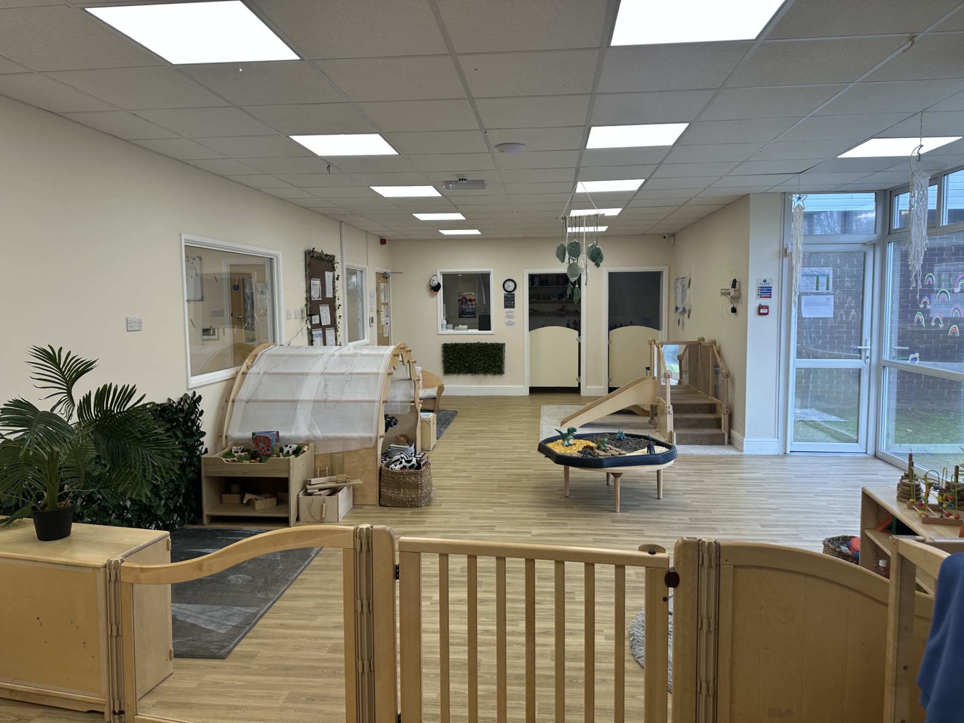 View from secure gated area of baby activities and small climbing apparatus at Partou Upton Day Nursery and Pre-School