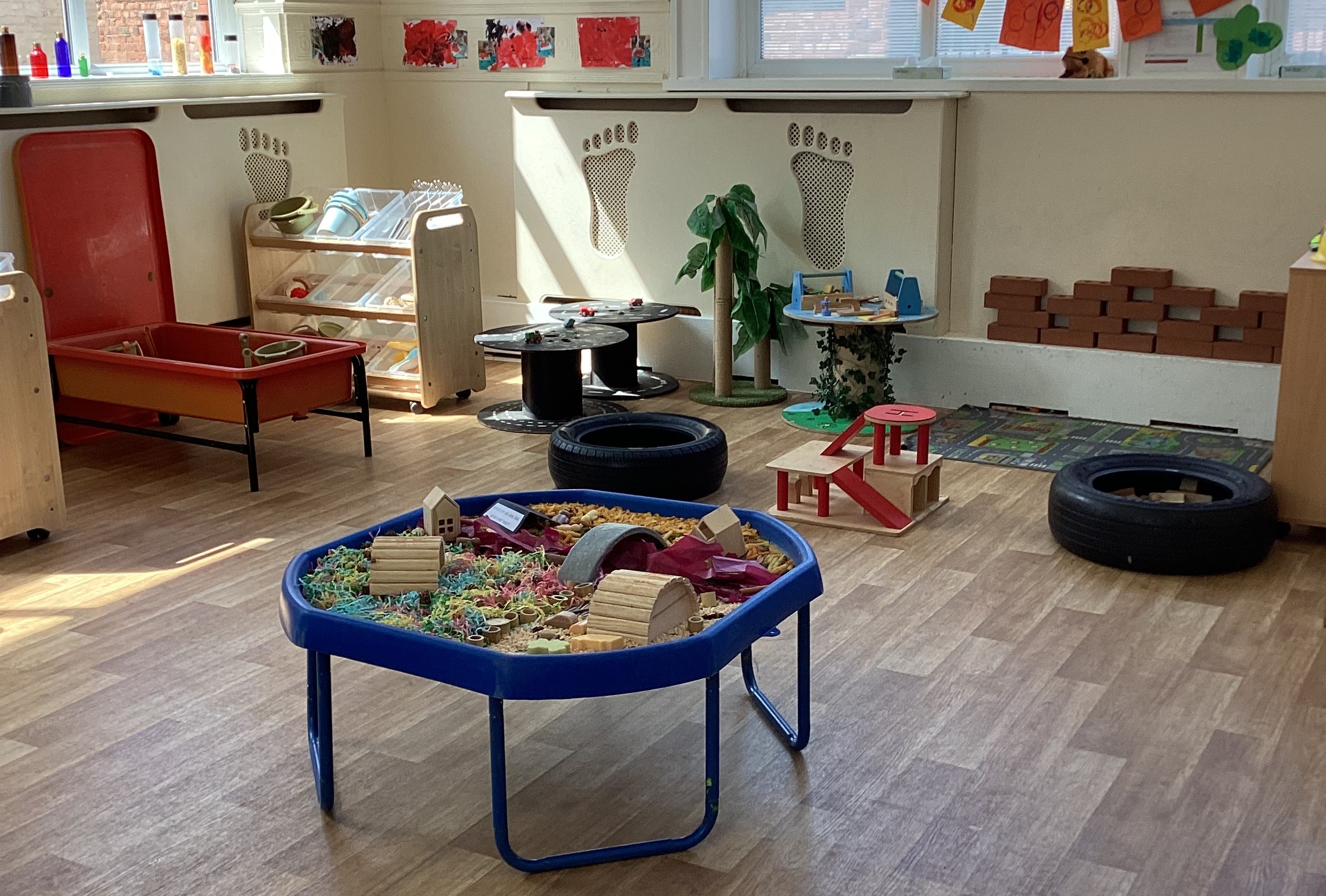 Sensory tray with construction area in the background including foam bricks and tyres at Partou Footprints nursery