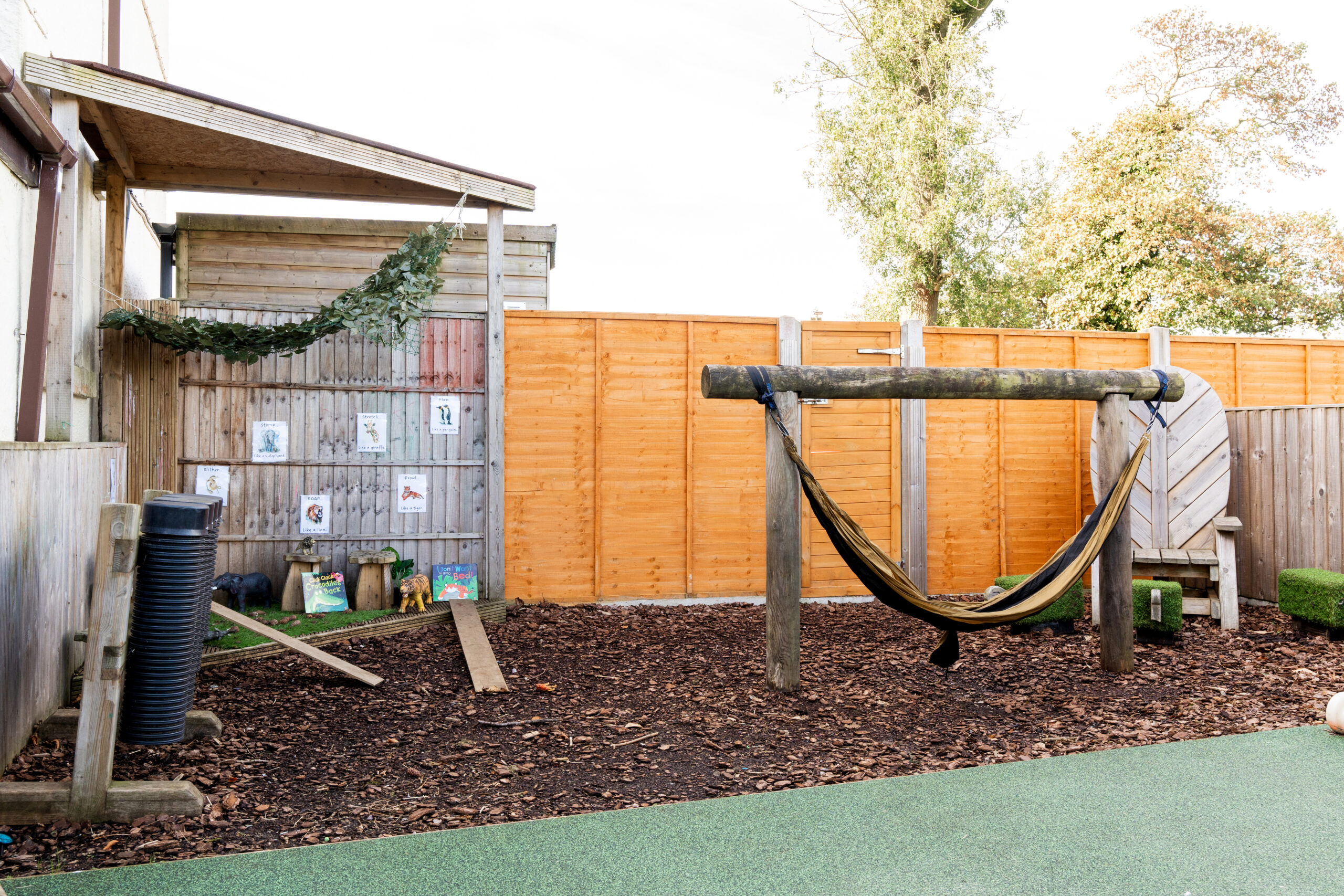 Wooden outdoor toys and hammock for exploration and sensory development at Hilltops nursery in Chorley