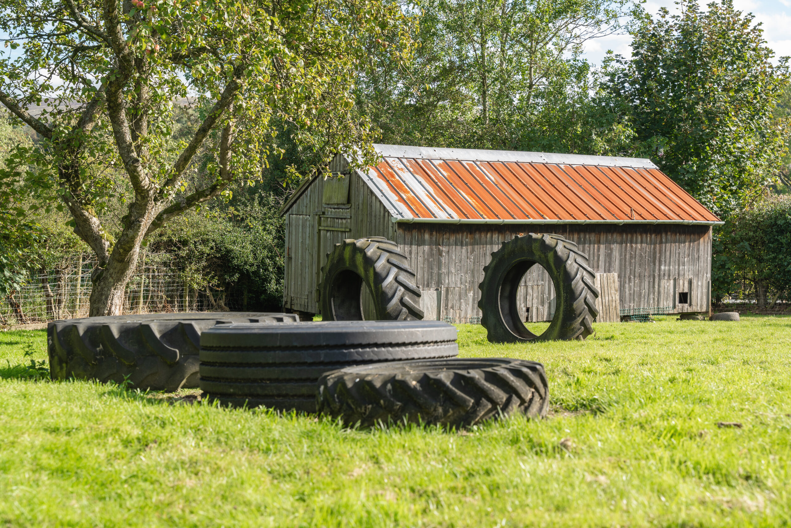 Outdoor play space with large tyres for play at Hilltops nursery in Chorley
