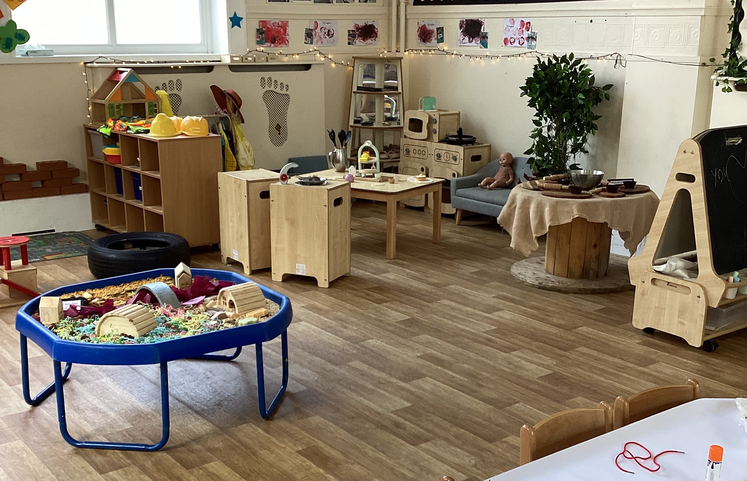 Home role play corner with wooden washing machine and oven at Partou Footprints nursery