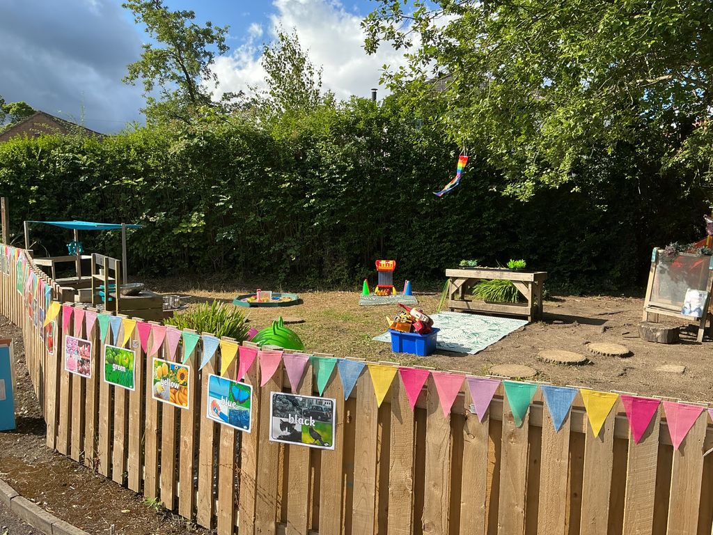 Large outdoor area with fence and bunting Partou Acorns in Adel nursery and pre-school in Leeds