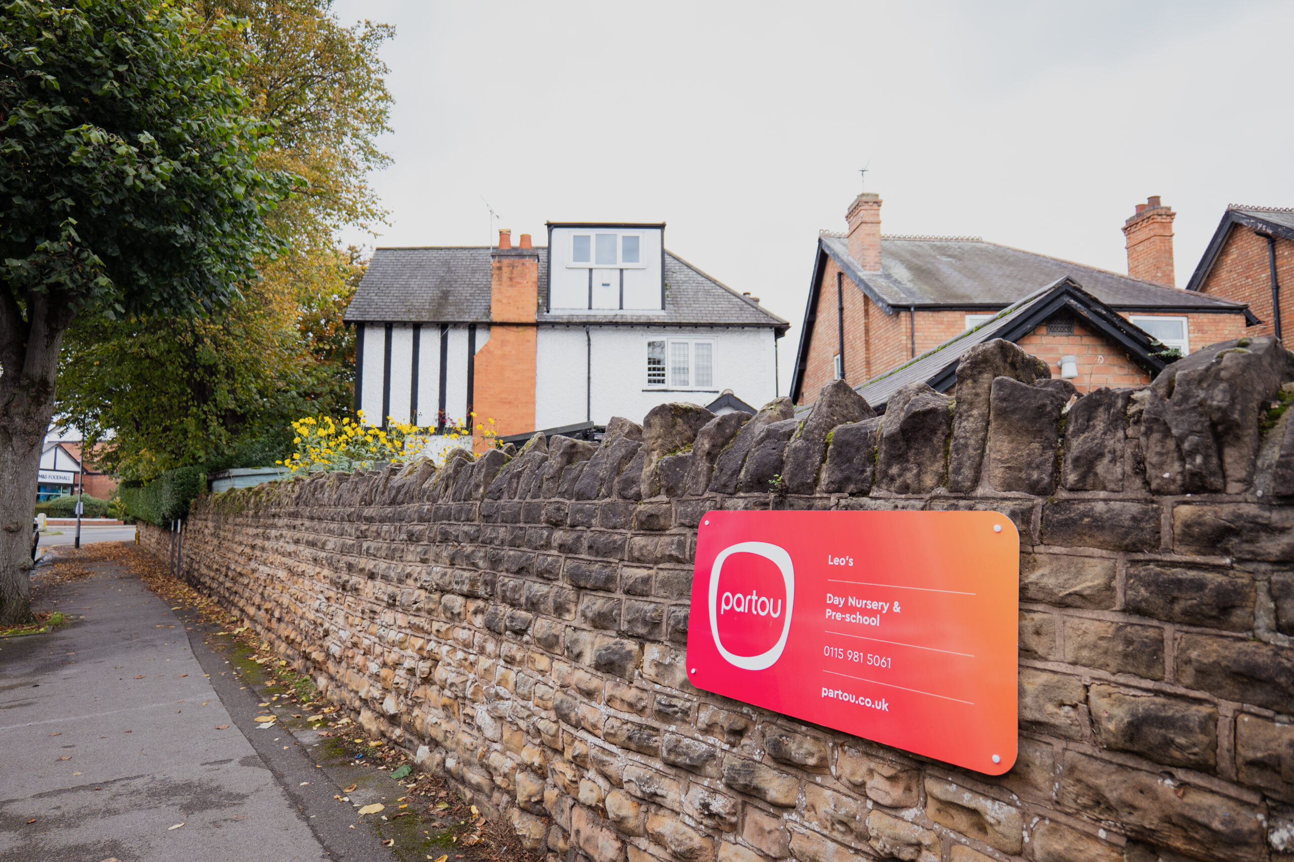 Stone brick wall and orange Partou signage at Leo