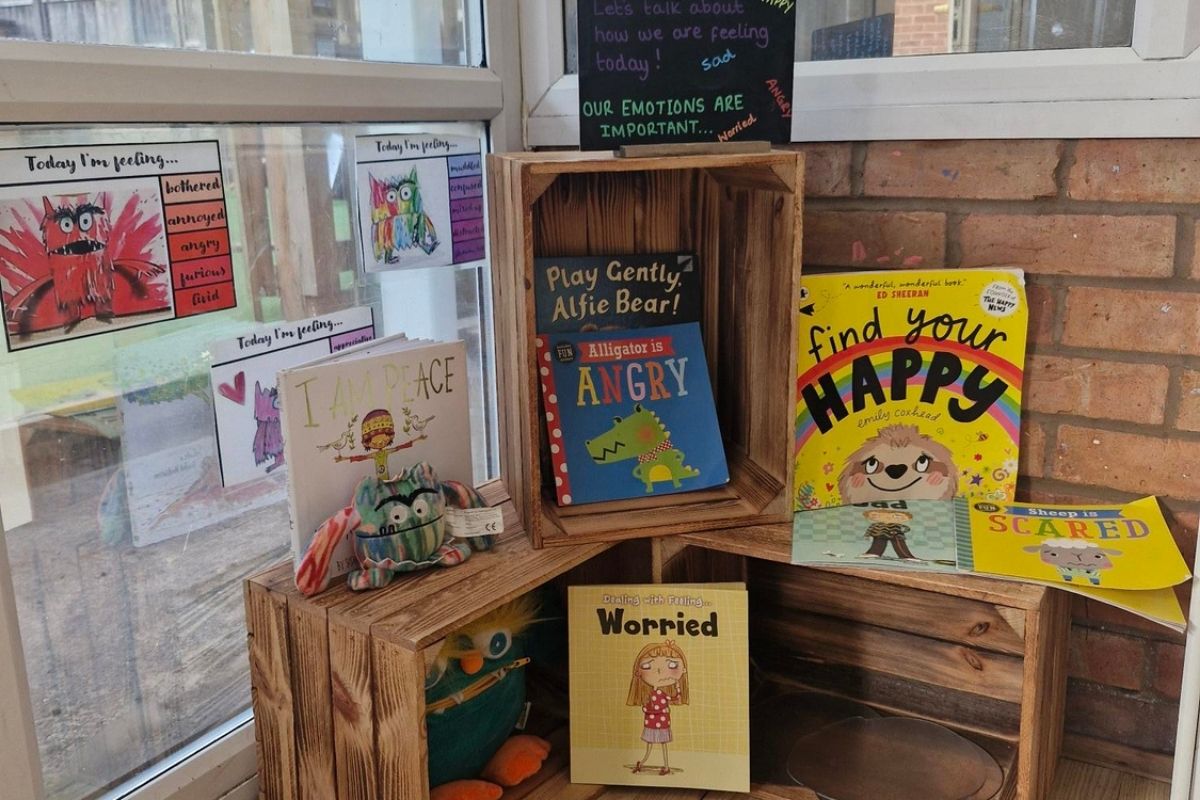 Personal, social and emotional development books encouraging emotional awareness and mindfulness with children on wooden boxes at Partou Barnwood Day Nursery & Pre-School in Glouceste