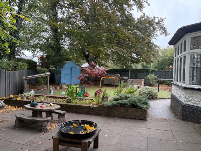 Outdoor space with grass, concrete and sensory toys set up at Partou Leo