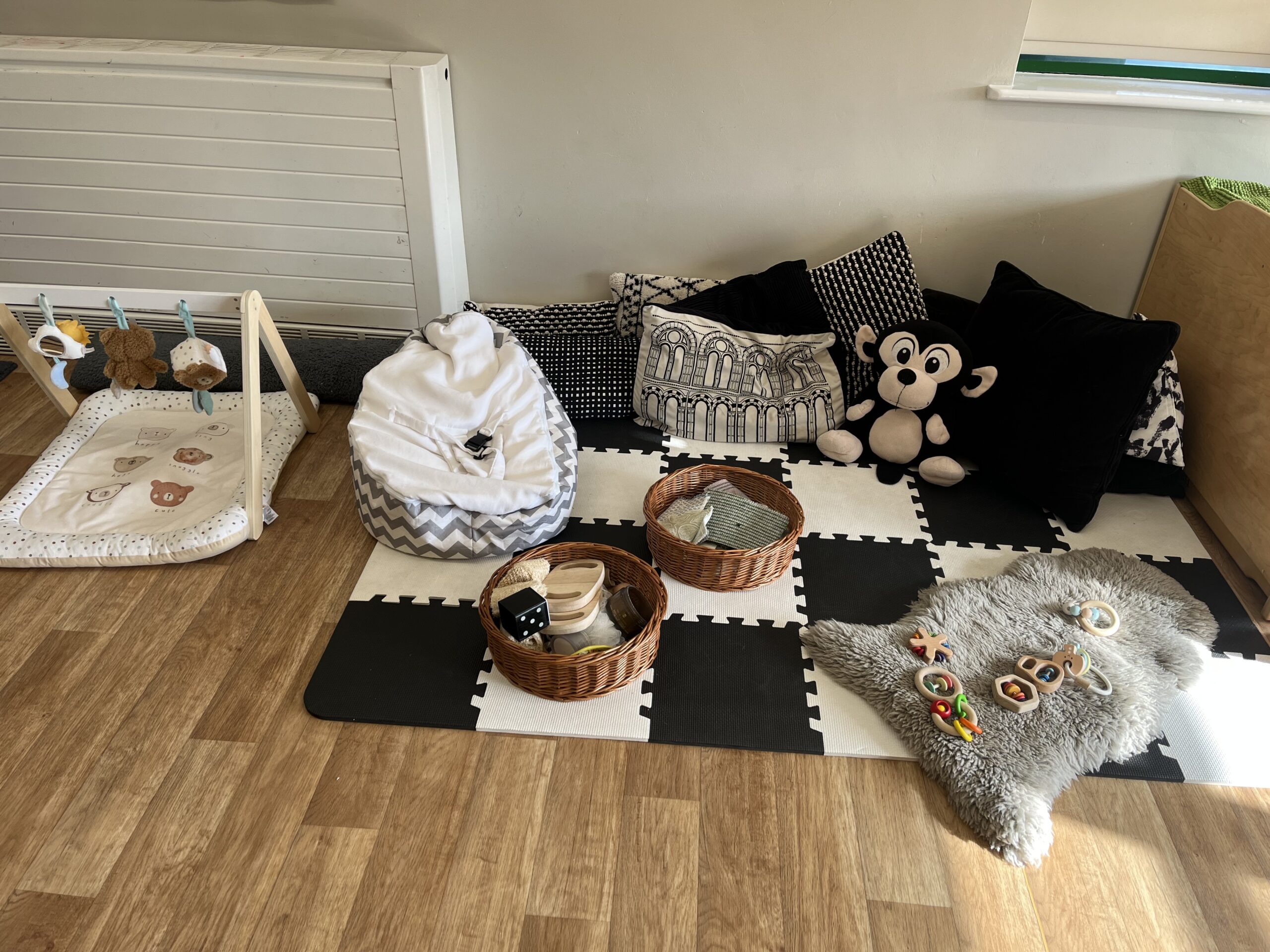 Black and white rug with sensory toys for babies at Partou Smileys nursery in Stafford