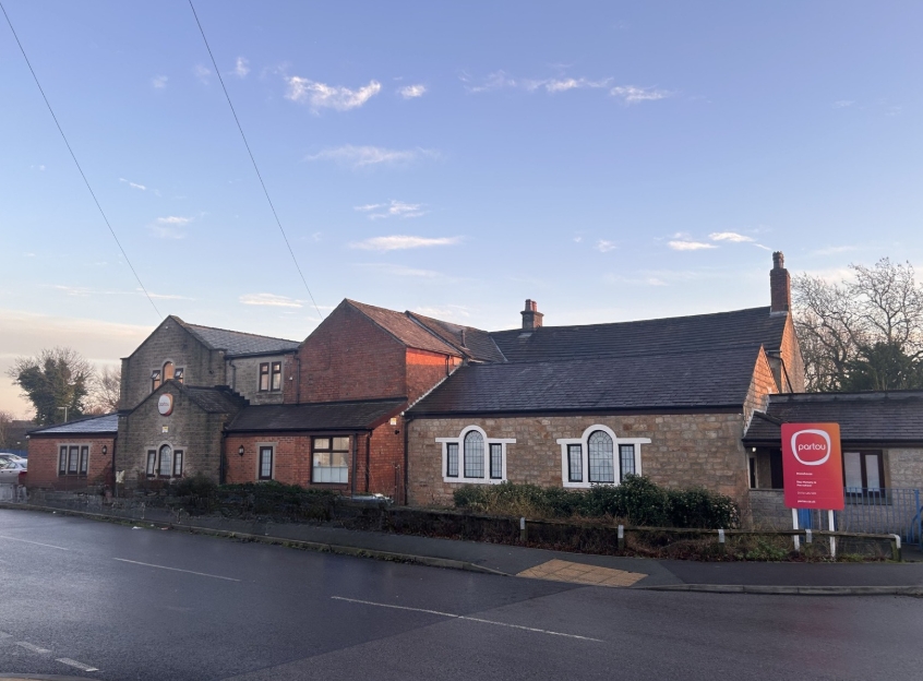 Large brick Partou Stonehouse Nursery building with blue fence and Partou sign outside