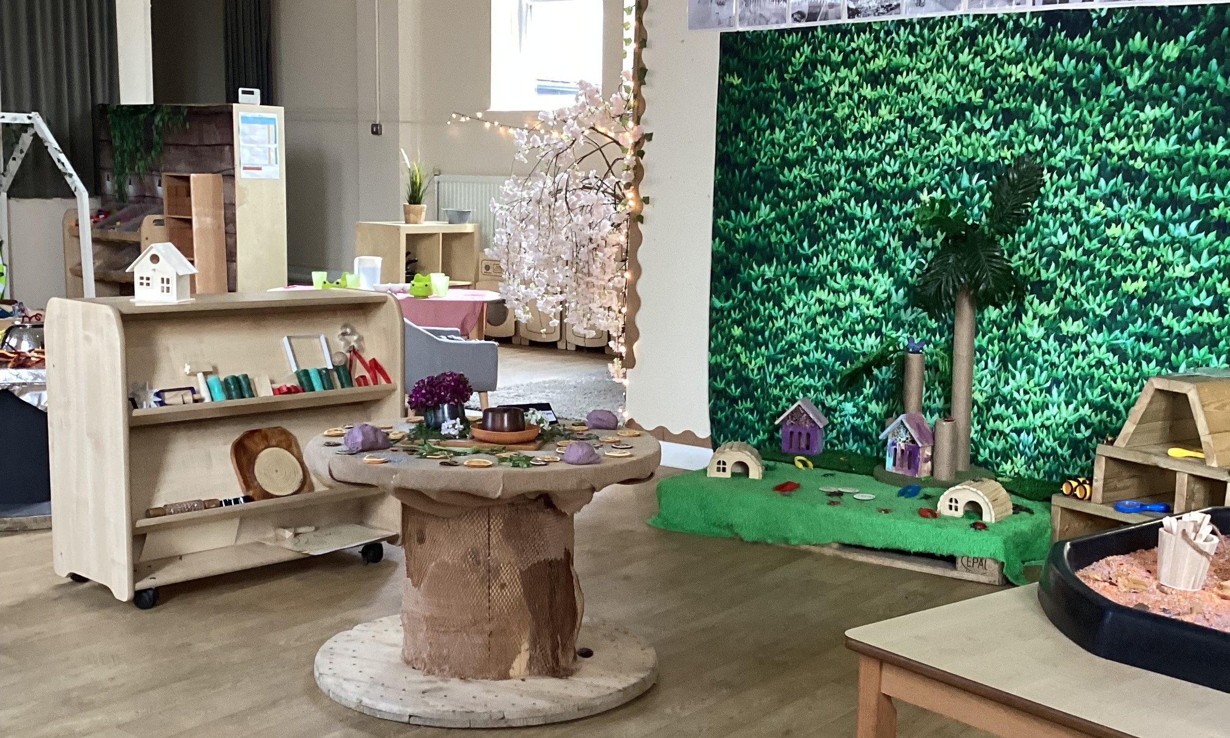 Wooden toys with fairy garden and foilage back drop at Partou Footprints nursery in Atherton