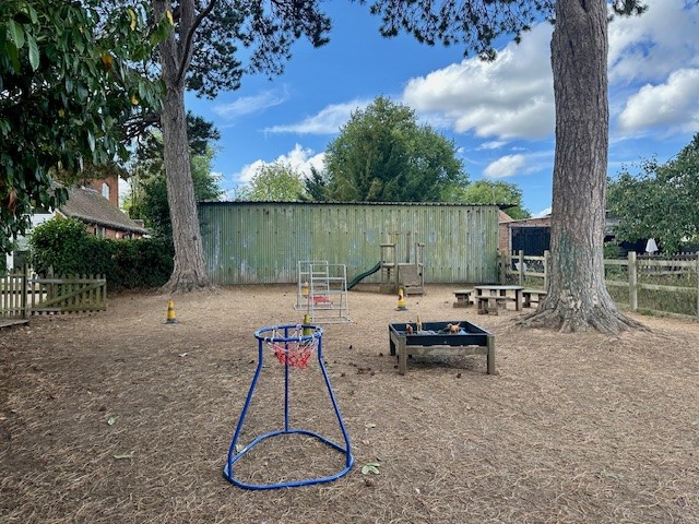 Large garden area with trees and pre-school play apparatus at Partou Langley Gorse Day Nursery in Sutton Coldfield