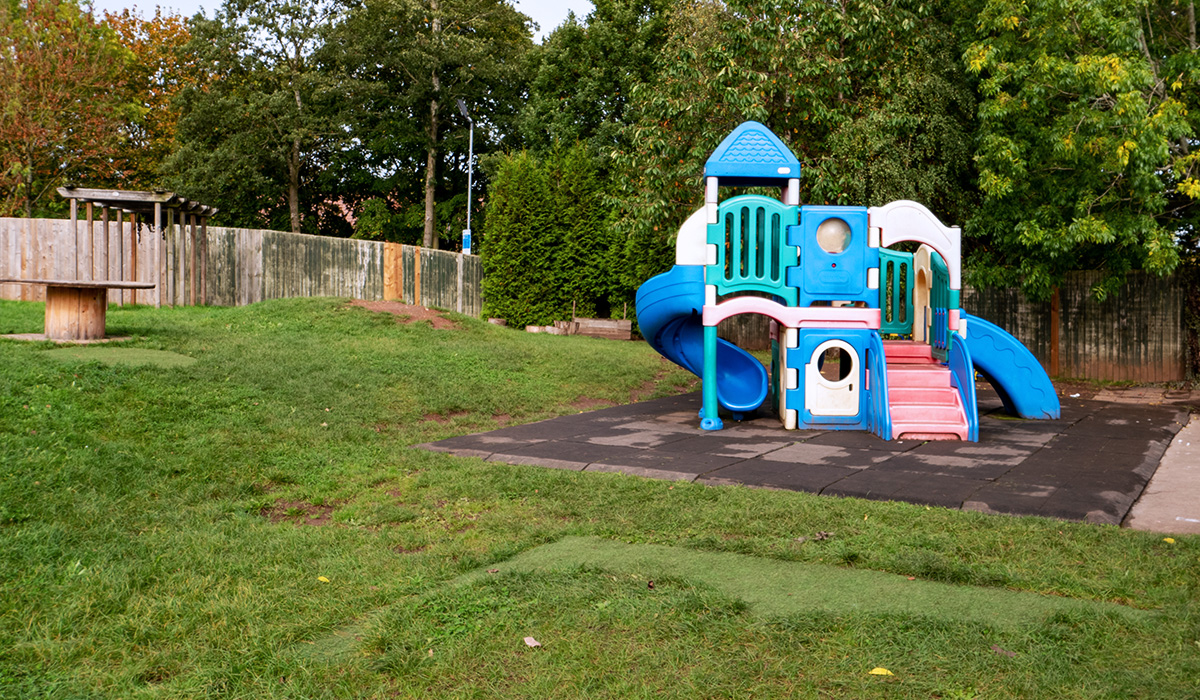 Outdoor play climbing area with slide on top of a soft impact-absorbing floor at Smileys nursery in Stafford