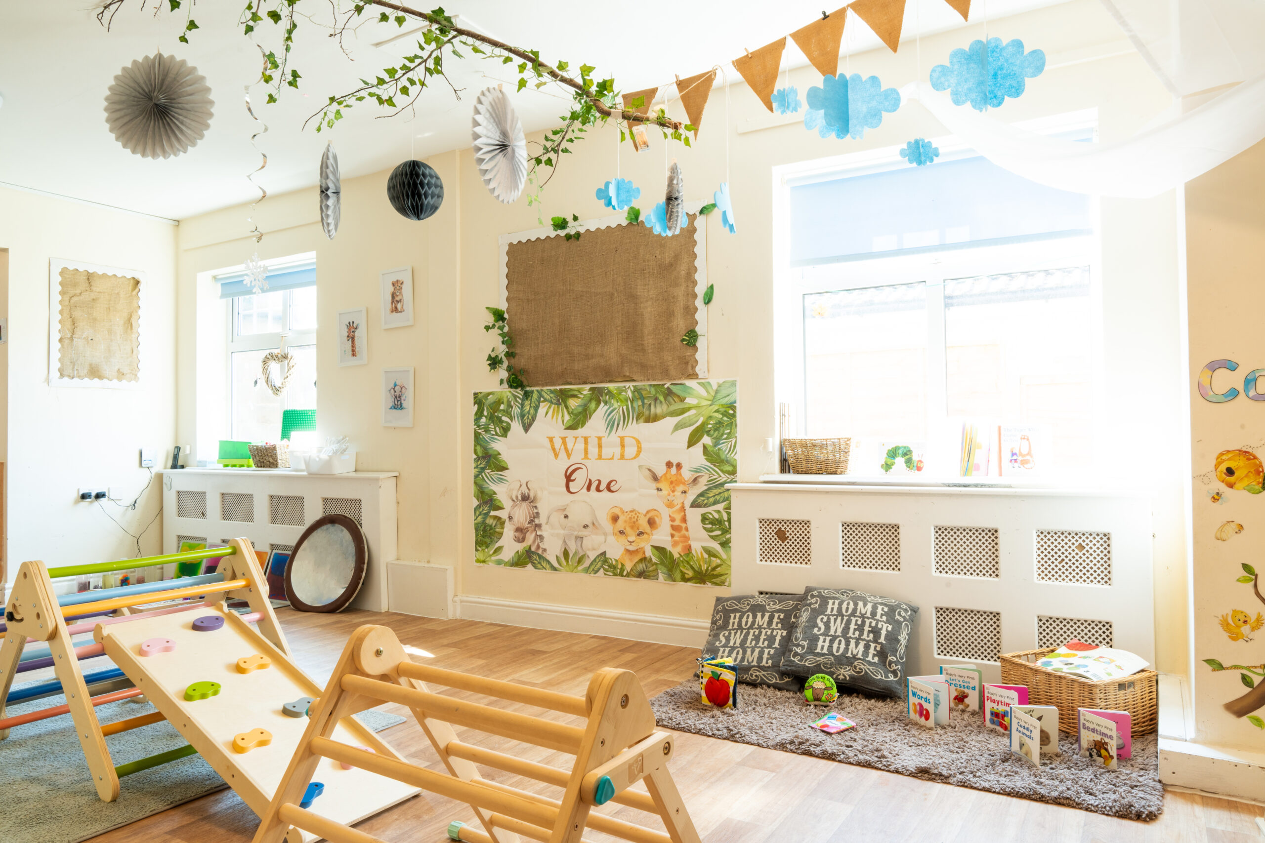 Bright and airy Toddler room at Safehands nursery in Harrogate with wooden play and balance structure and books