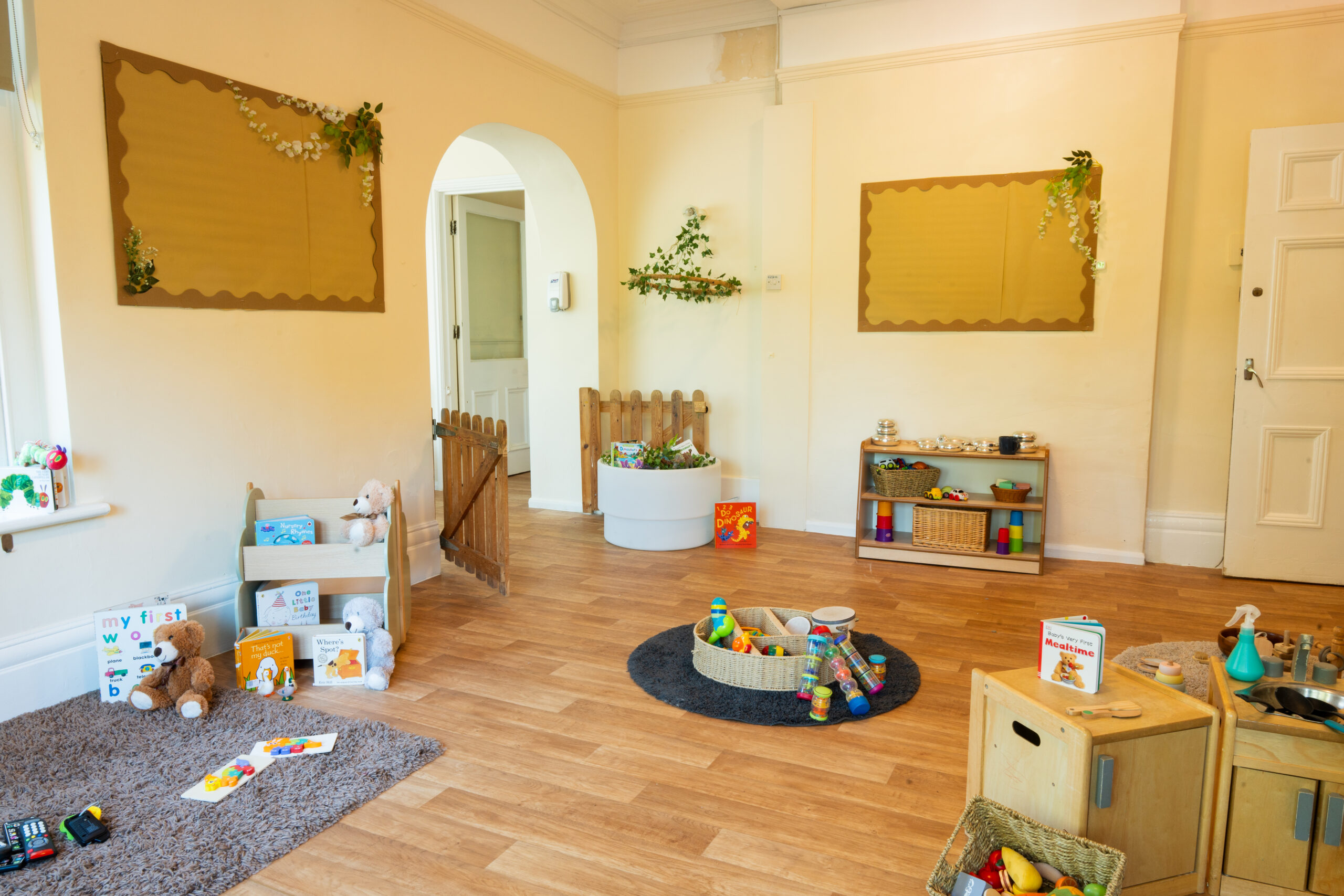 Safehands nursery playroom with neutral decor and natural light with books and musical instruments for children to explore