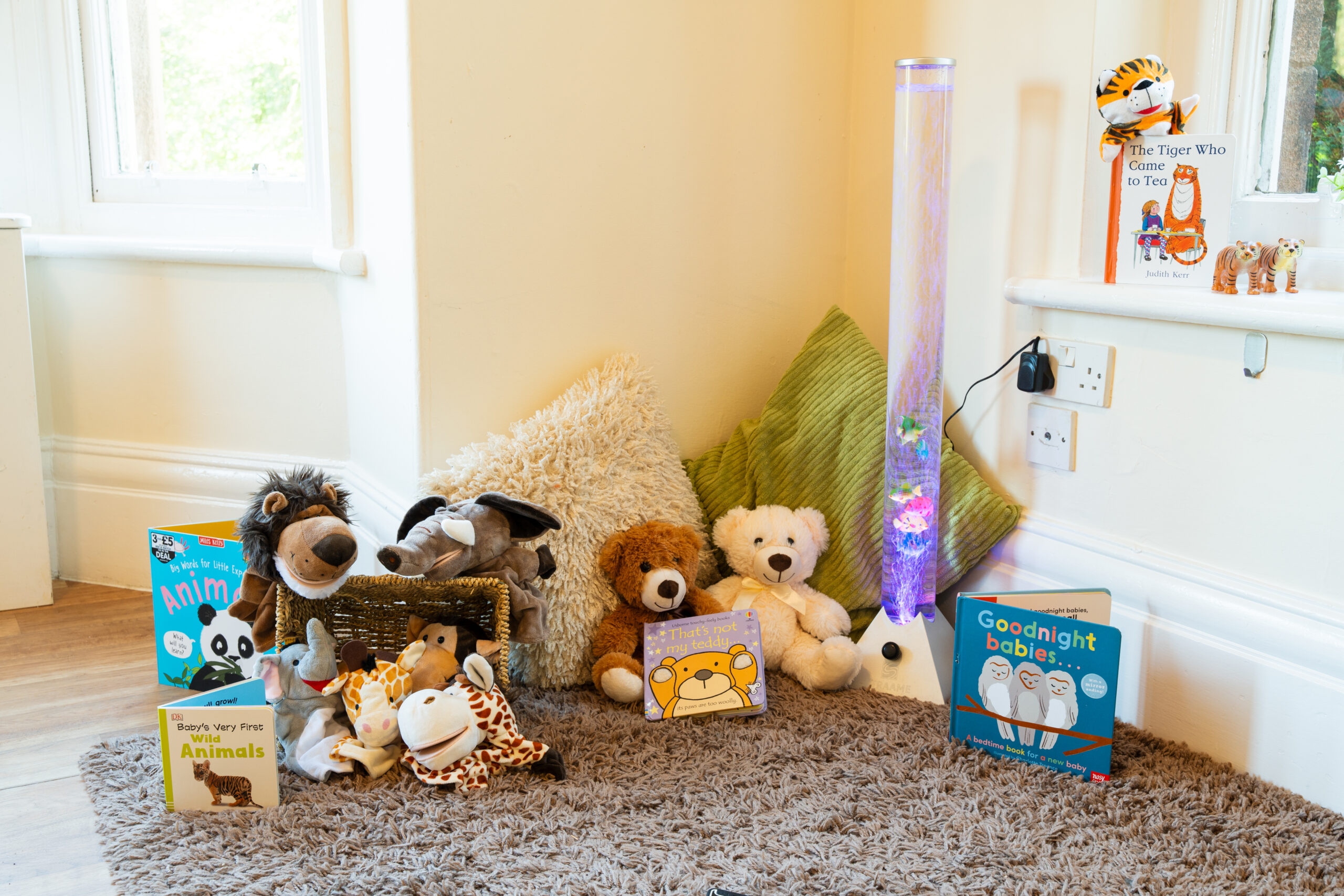 Reading area at Safehands nursery in Harrogate with comfortable rug, teddies, books and a sensory bubble lamp