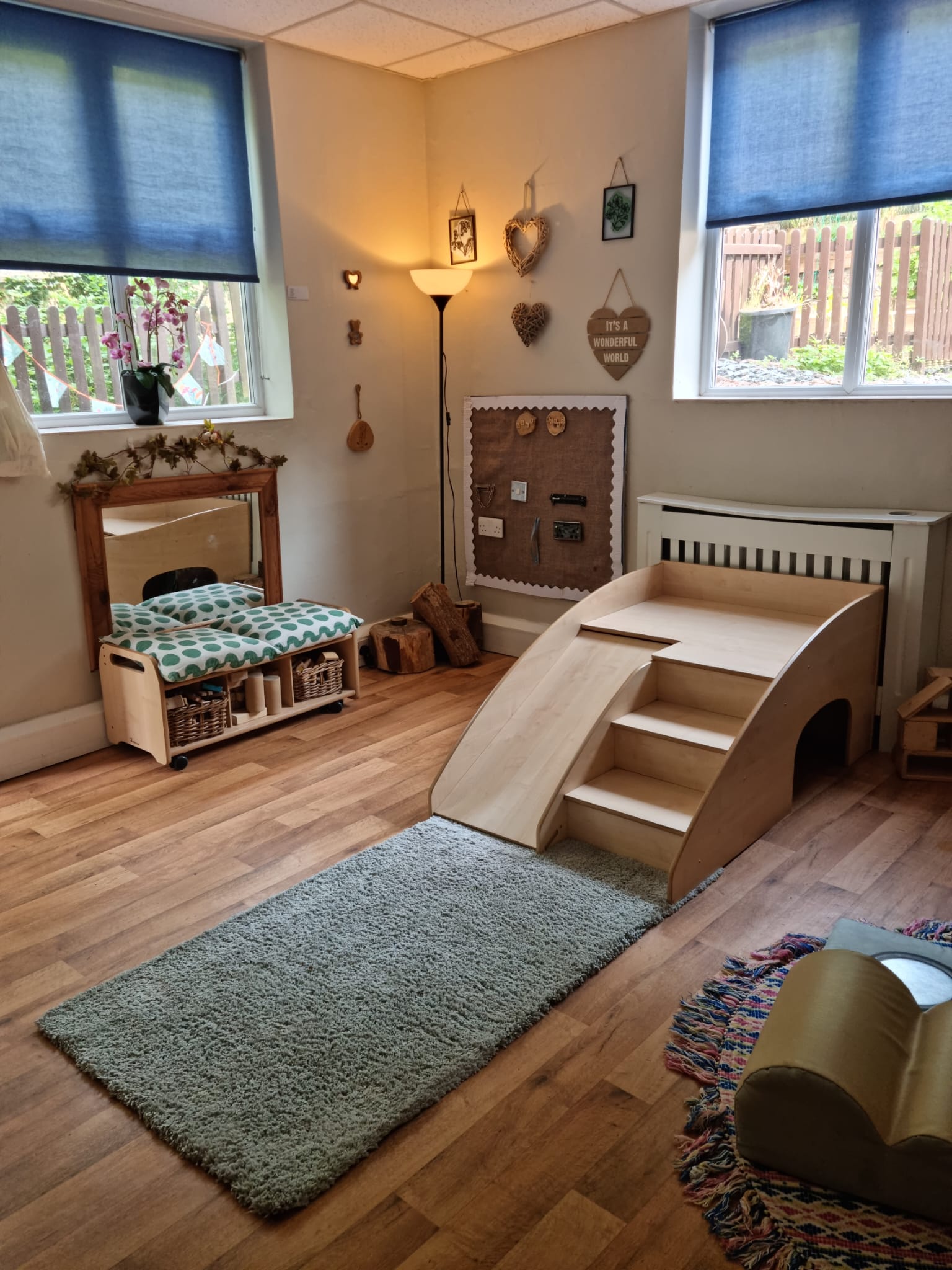 Toddler wooden indoor slide and steps with seating area at Sycamore House nursery in Bishop