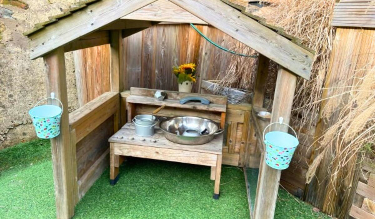 Outdoor mud kitchen in sheltered area at Sycamore House day nursery in Bishop