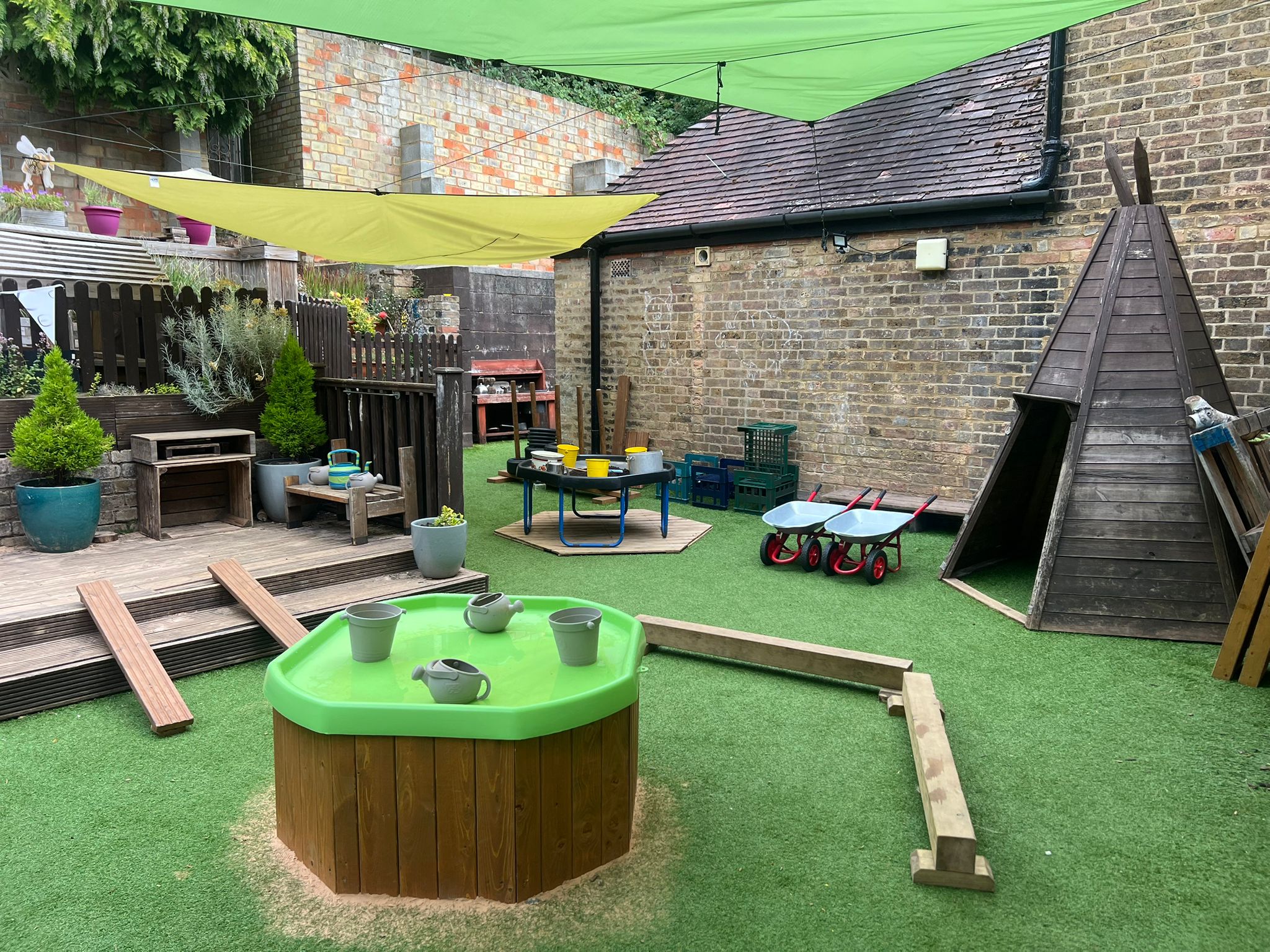 Outdoor exploration area with water play and balance beams at Sycamore House in Bishop