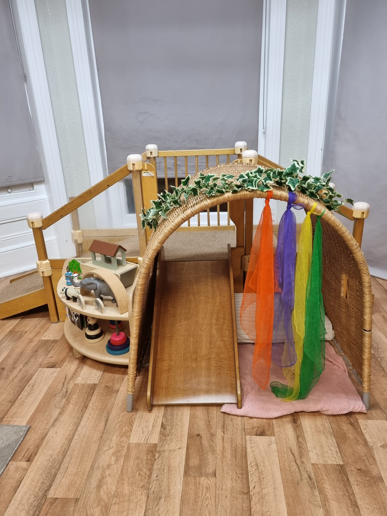 Toddler indoor wooden slide with slopes and steps at Sycamore House nursery in Bishop
