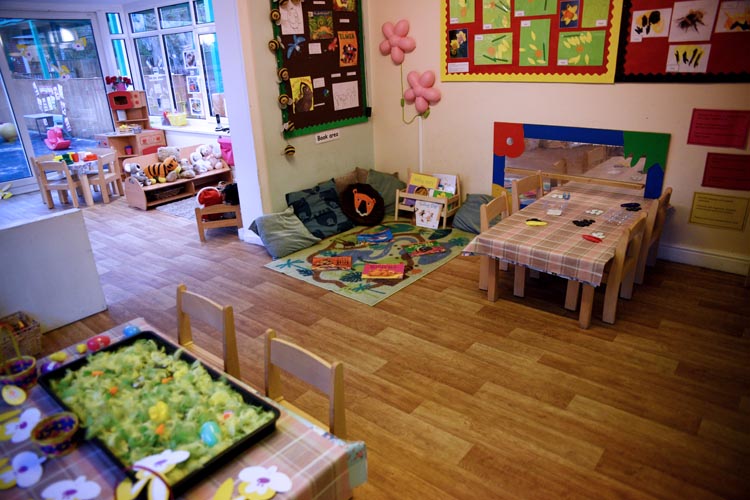 Wooden table and chairs with sensory play set up in trays at Partou Acorns in Adel nursery and pre-school in Leeds