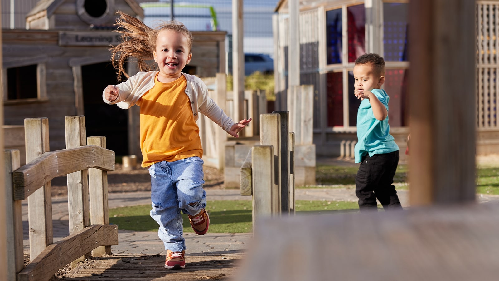 Young girl running, in a nursery outdoor space