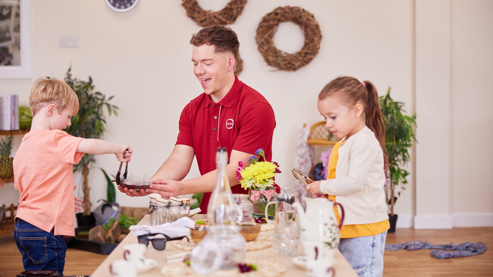 Two young children playing with various items on a large table