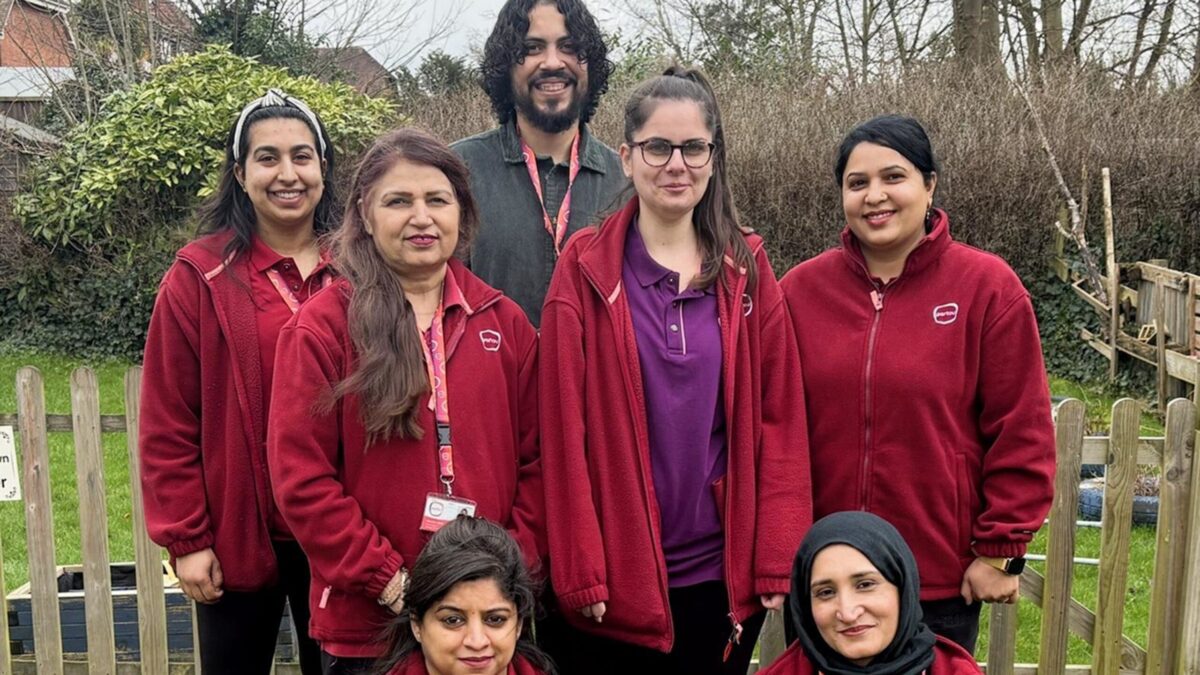 Partou Silchester Manor nursery team members pose outdoors by a fenced garden area following a positive Ofsted inspection outcome.