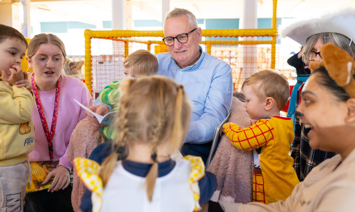 Children’s author Matt Newnham reads a book aloud to a small group of young children during a storytime session at Partou Playtimes Day Nursery & Pre‑school in Shepperton.