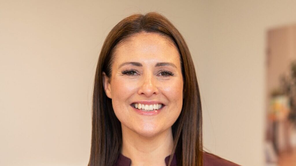 Portrait of Kirsty Jackson, Co-Managing Director at Partou, smiling at the camera against a softly blurred indoor background.